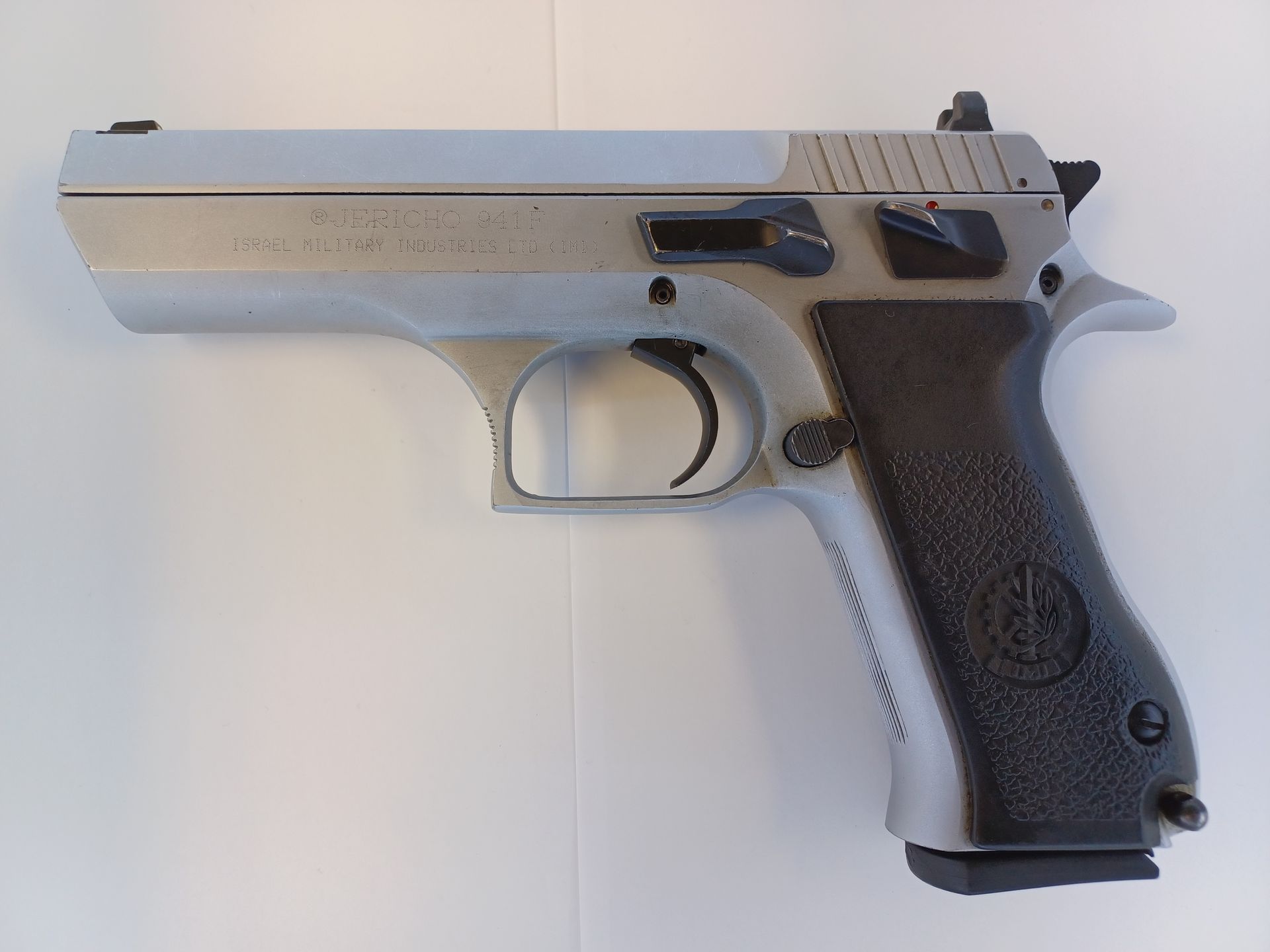 Silver and black handgun on white surface.