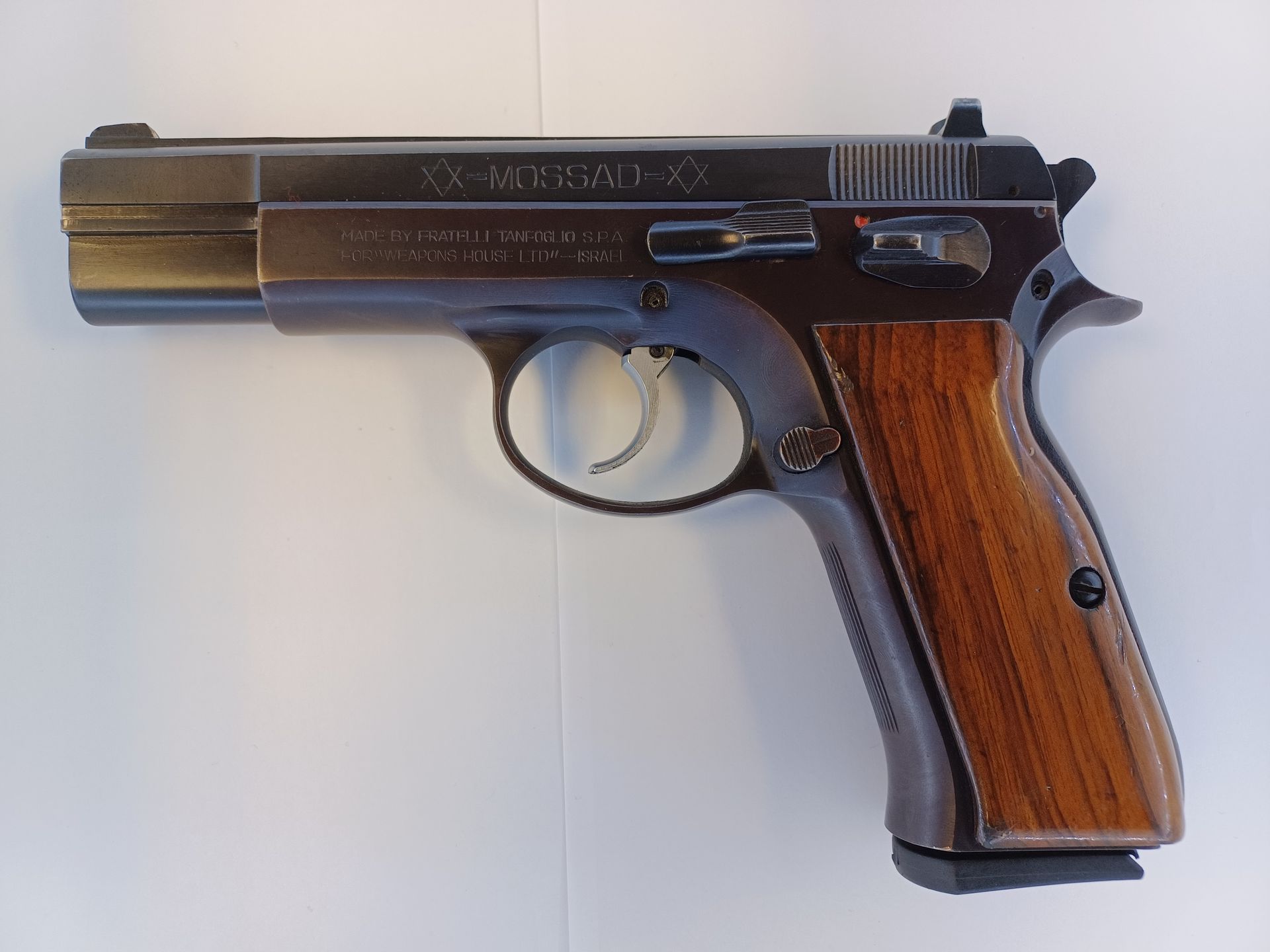 CZ-75 handgun with wooden grips, on a light background.