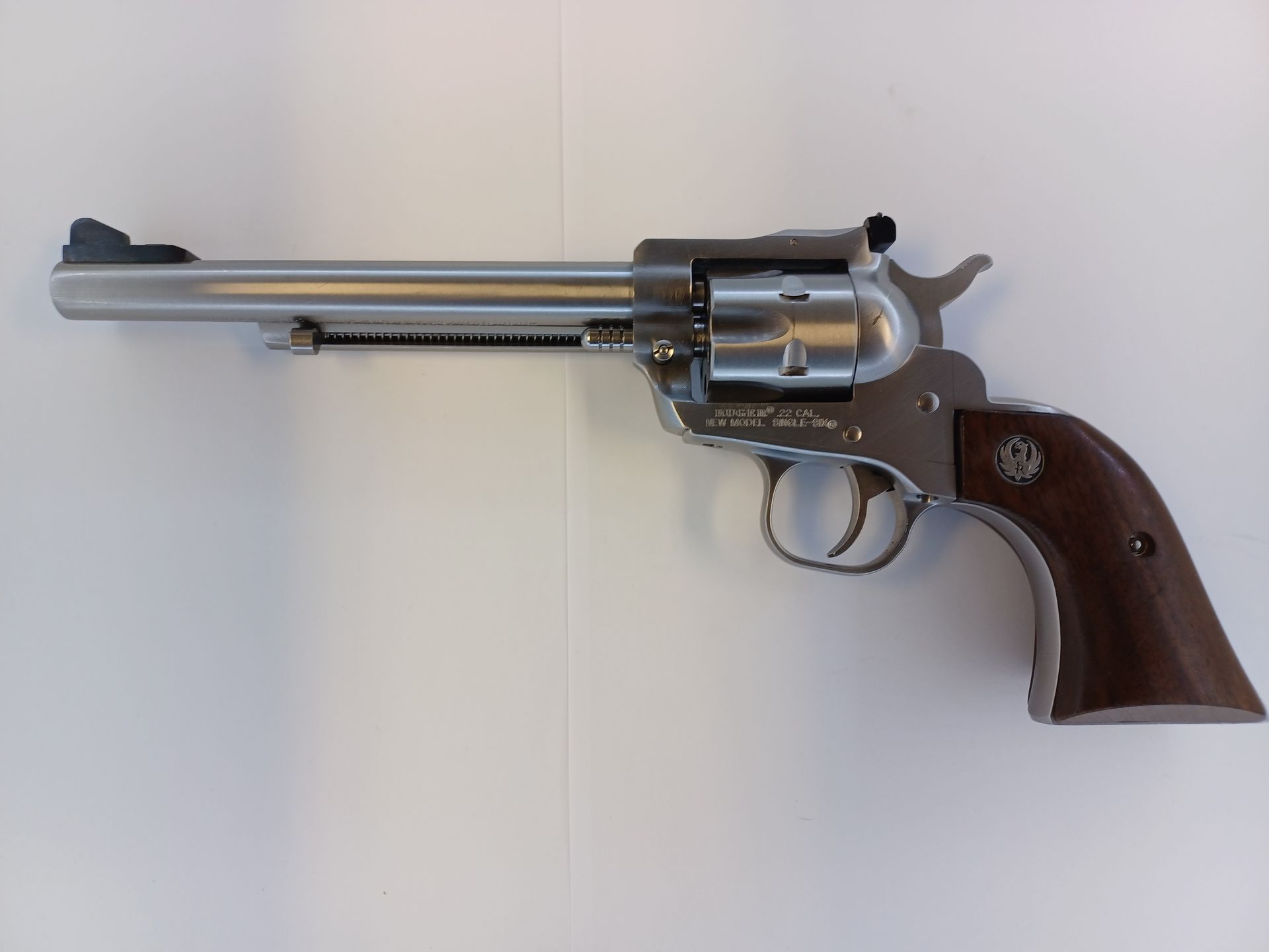Silver Ruger revolver with a wooden handle on a white surface.