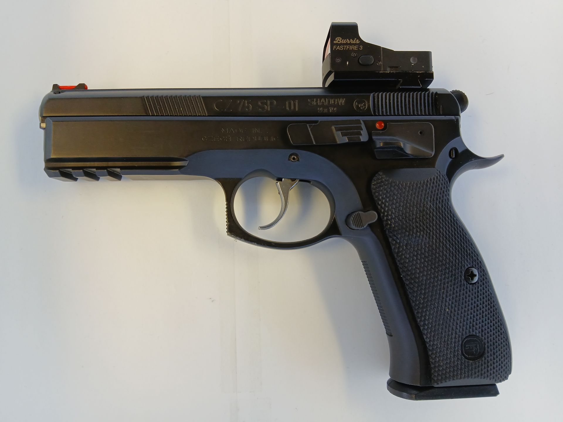 Black handgun with a red dot sight, blue accents, and a textured grip.