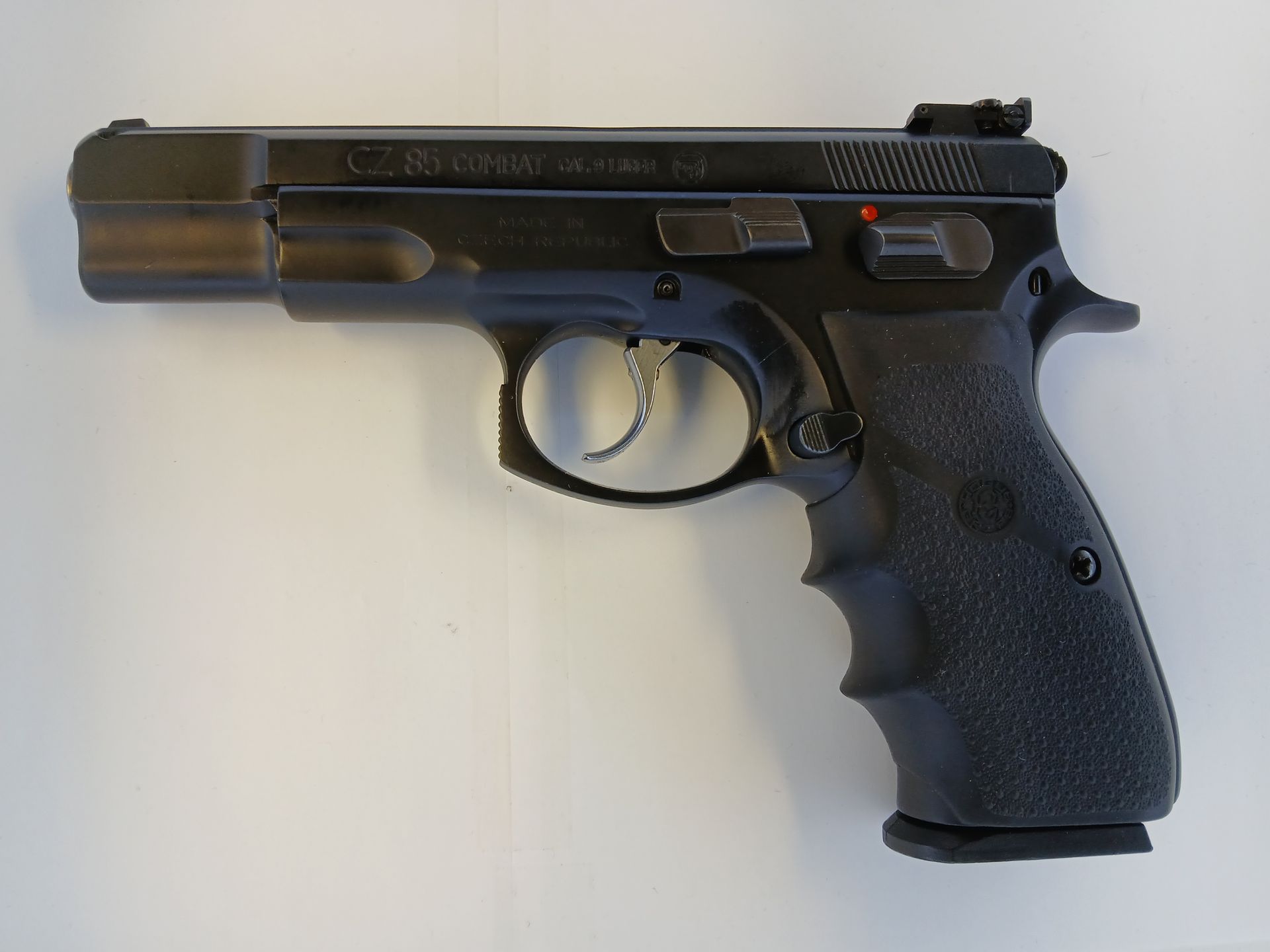 Black CZ-75 handgun with ergonomic grip, on a white surface.