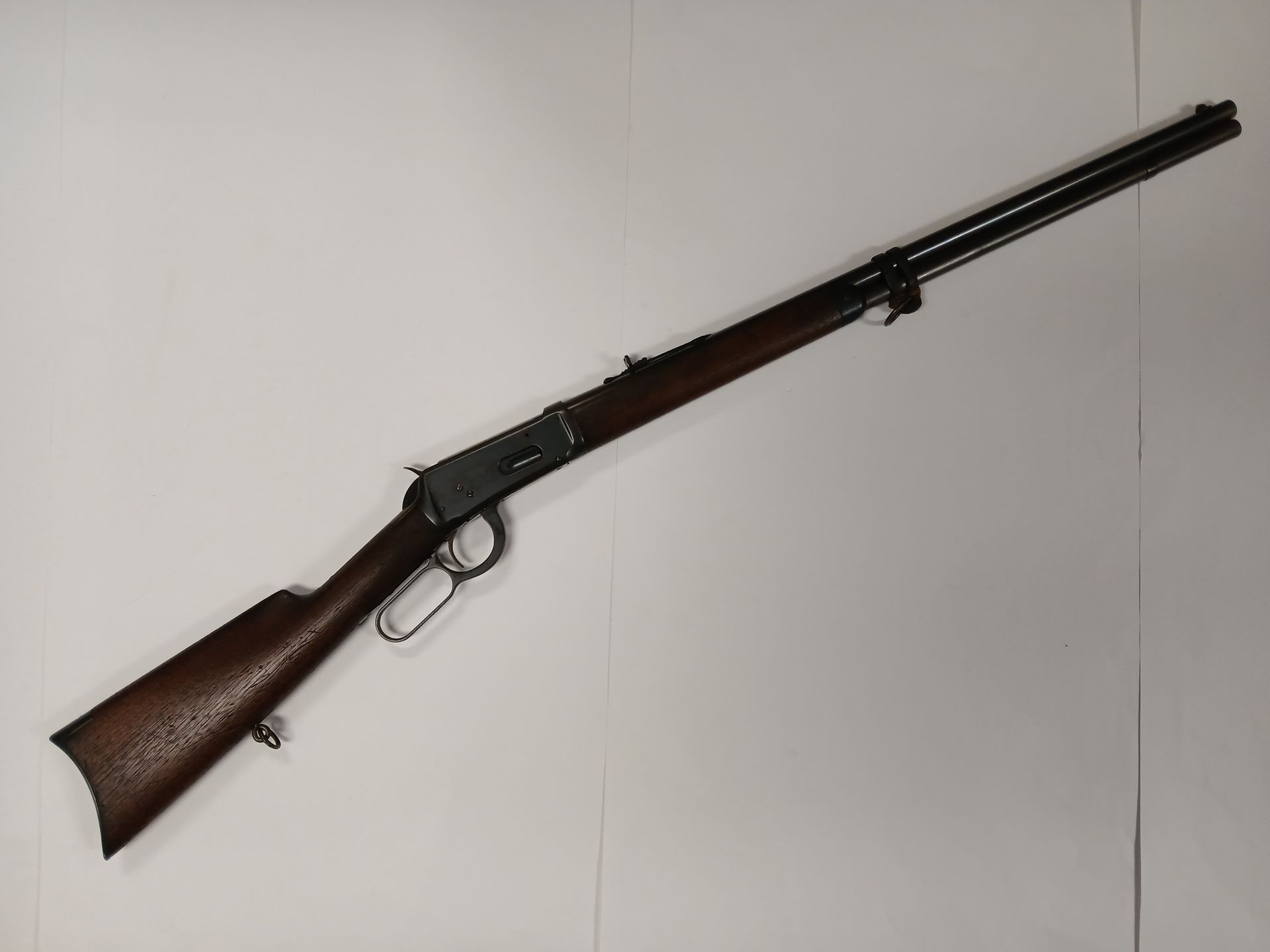 Carabine à levier, crosse et avant-bras en bois marron, canon et récepteur noirs, sur fond blanc.