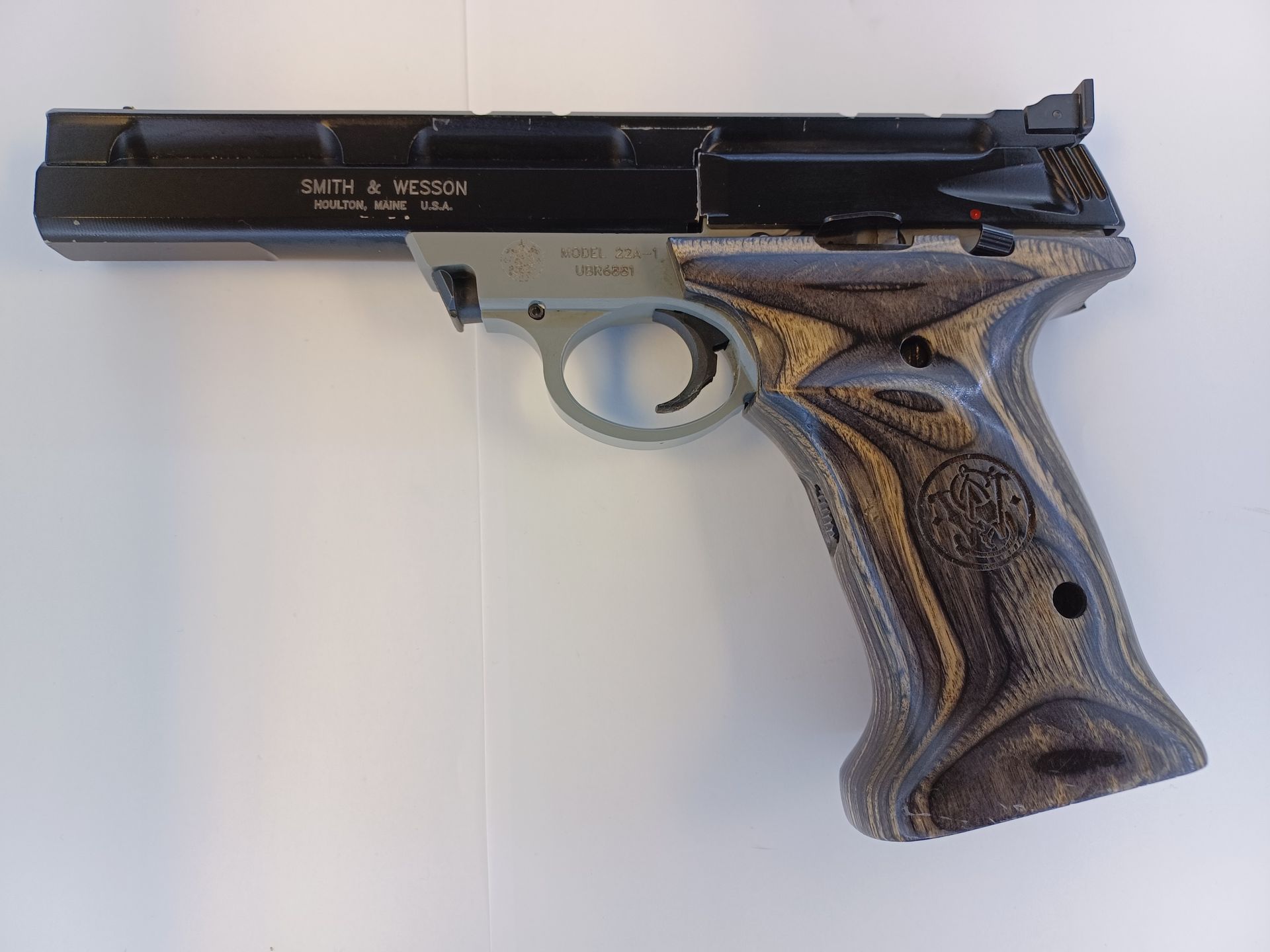 Smith & Wesson pistol with wooden grip, black slide, and silver frame.