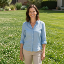Satisfied homeowner in front of a maintained lawn