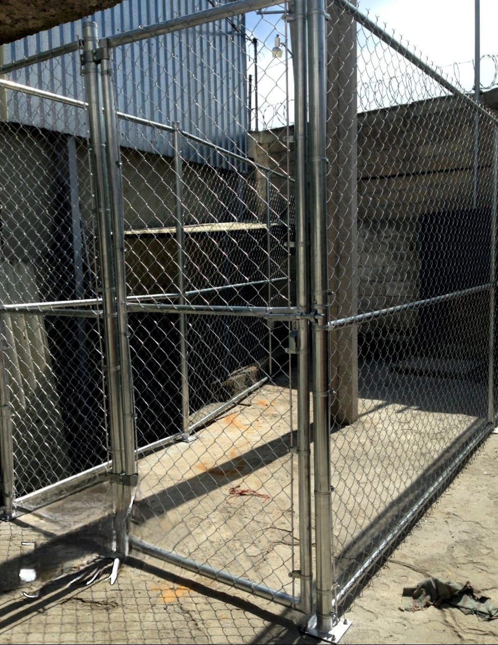 Una valla de alambre está colocada en el suelo delante de un edificio.