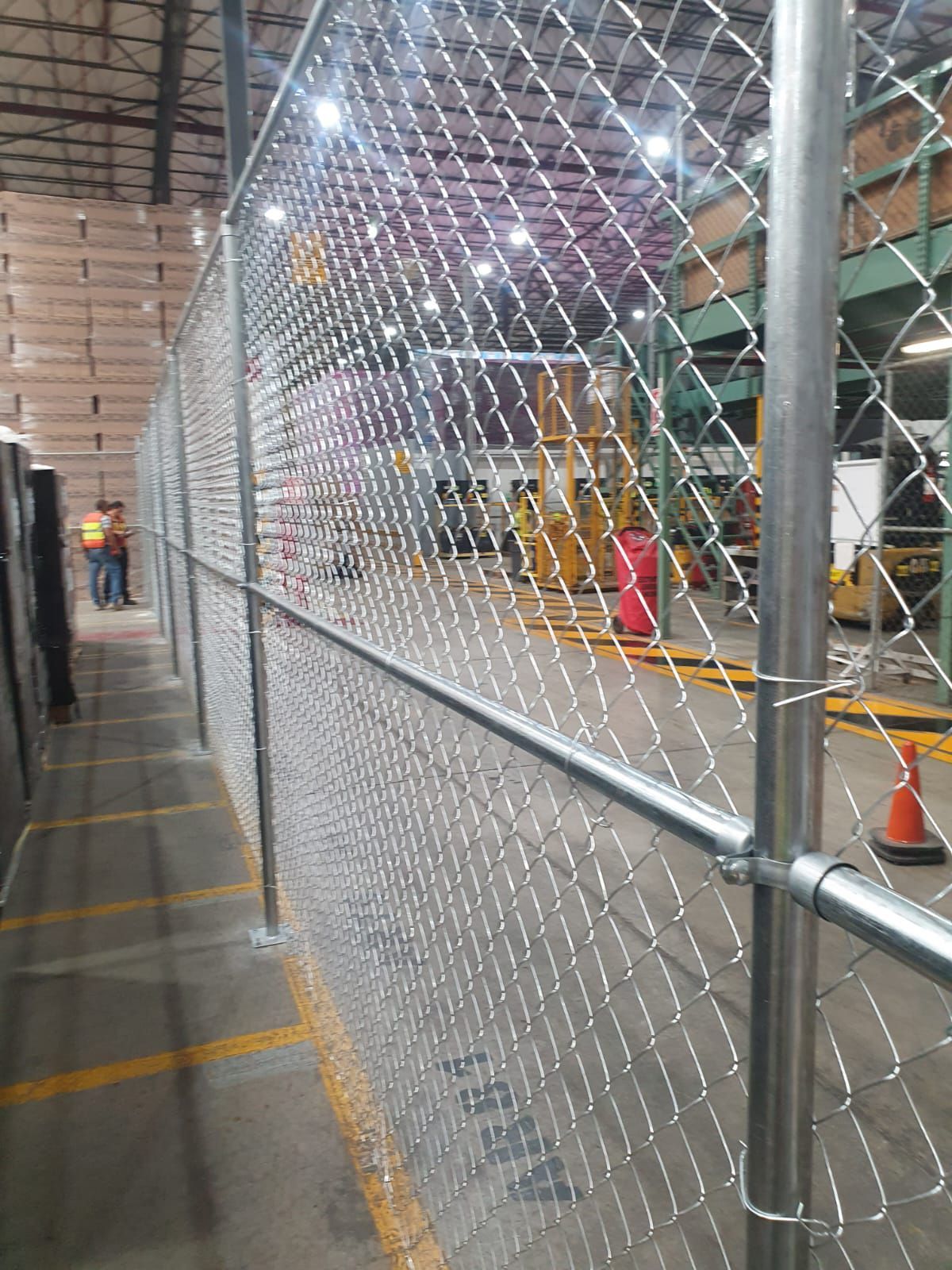 Se está instalando una valla de eslabones de cadena en un almacén.