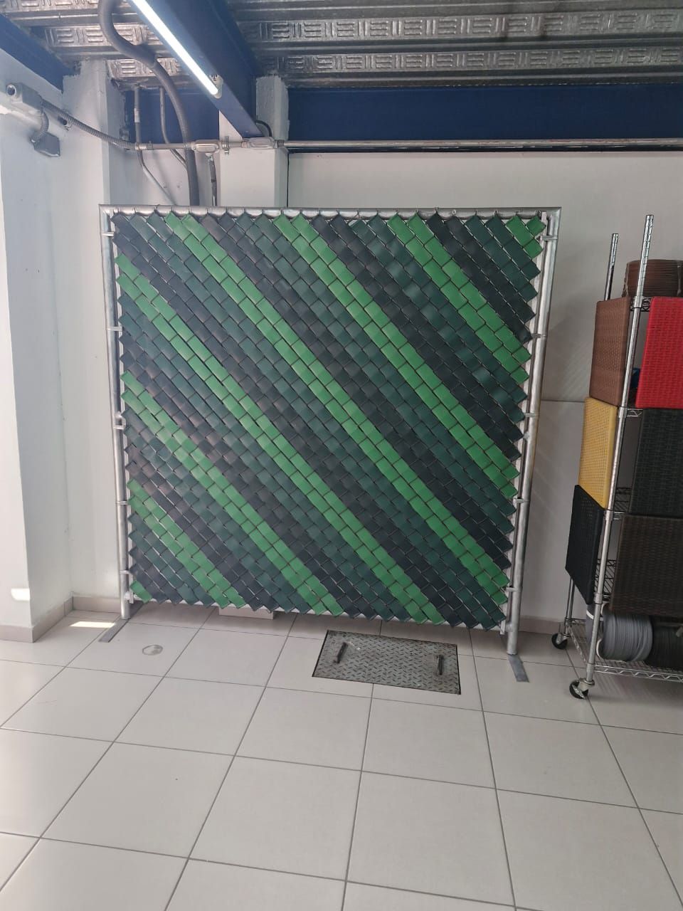 Una valla de rayas verdes y negras está en una habitación.