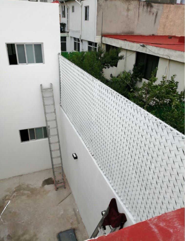 Una pared blanca con una escalera unida a ella.