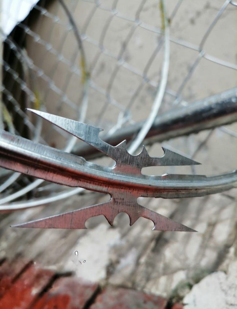 Un primer plano de alambre de púas en una cerca de alambre de cadena.