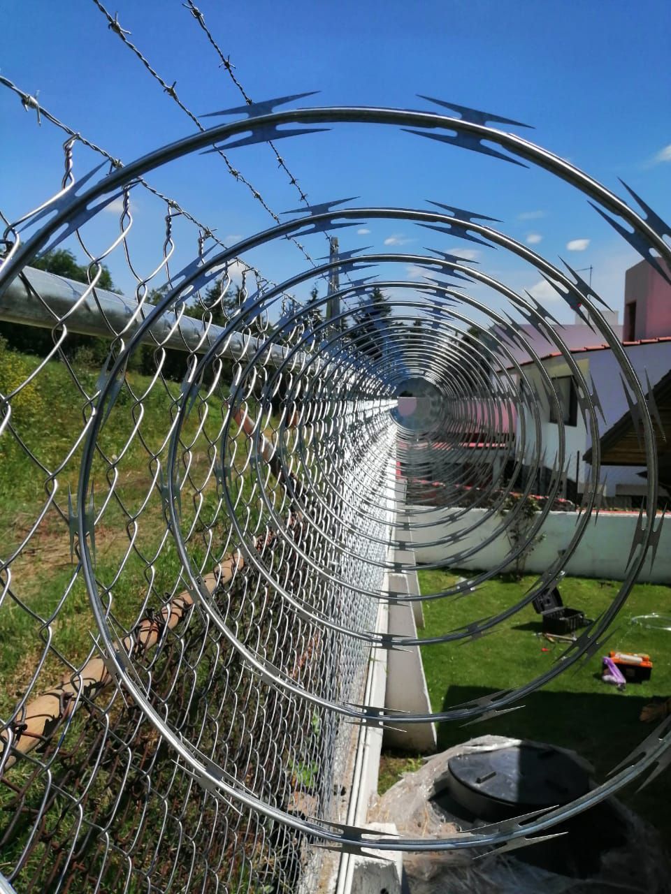 Una valla de alambre de púas con un cielo azul al fondo