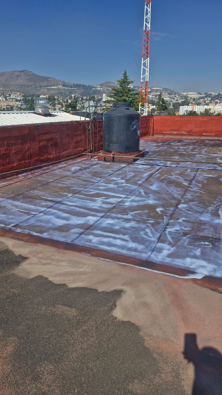 Una persona está tomando una fotografía de un techo con una torre al fondo.