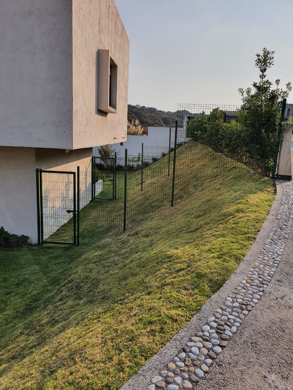 Un camino de piedra que conduce a una casa en una colina.