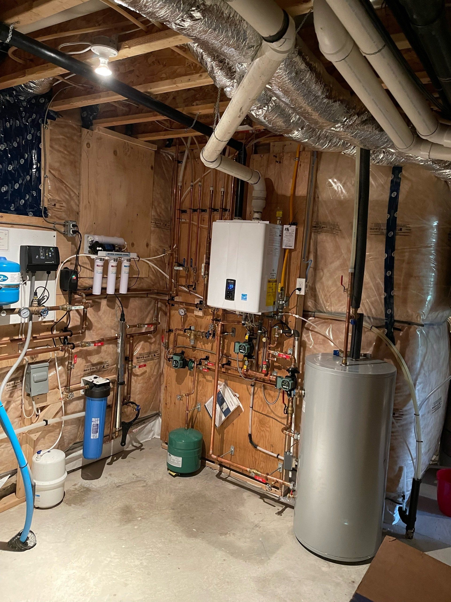 A basement with a water heater and a vacuum cleaner.