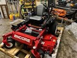 A red lawn mower is sitting on top of a wooden pallet in a garage.