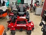 A red lawn mower is parked in a garage.