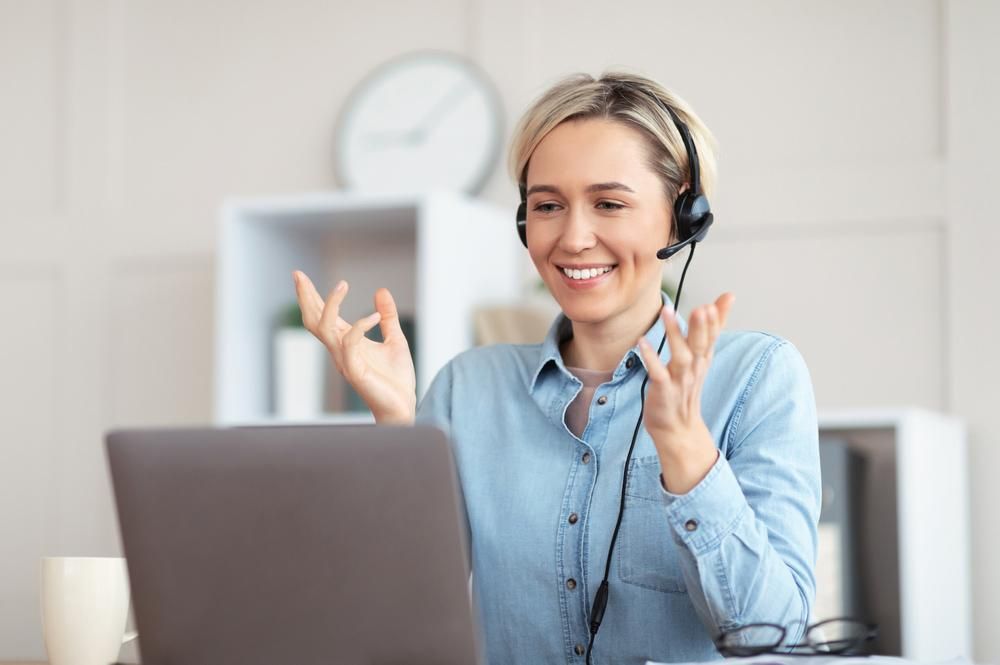 A Woman Wearing a Headset Is Sitting in Front of A Laptop Computer — Al Roberts Education Centre in Wynnum West, QLD
