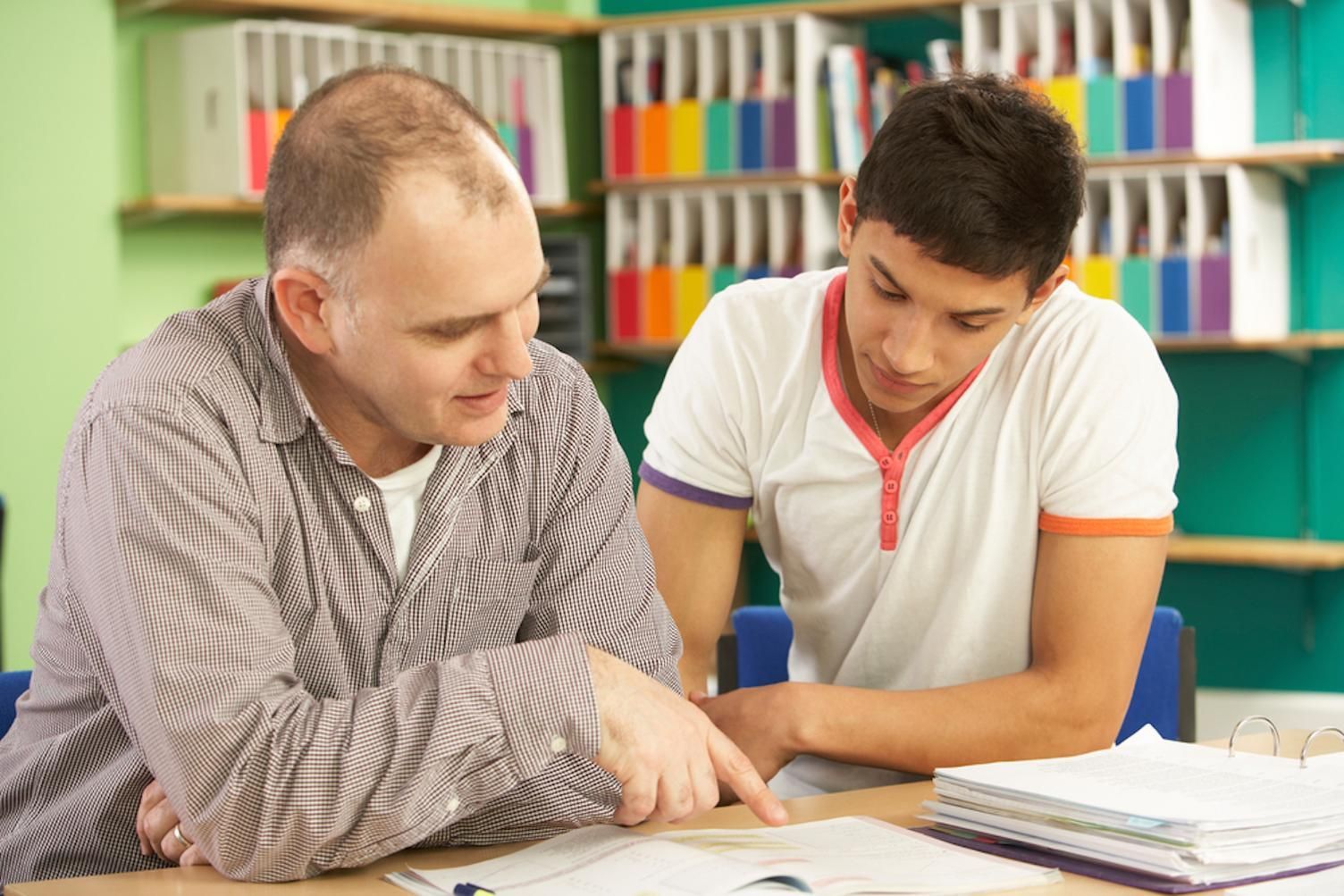 A Man Is Helping a Young Man with His Homework in A Library — Al Roberts Education Centre in Wynnum West, QLD