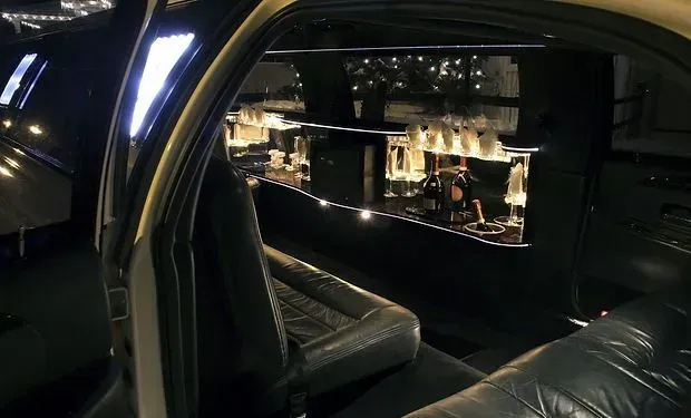 The inside of a limousine with a bar in the back.
