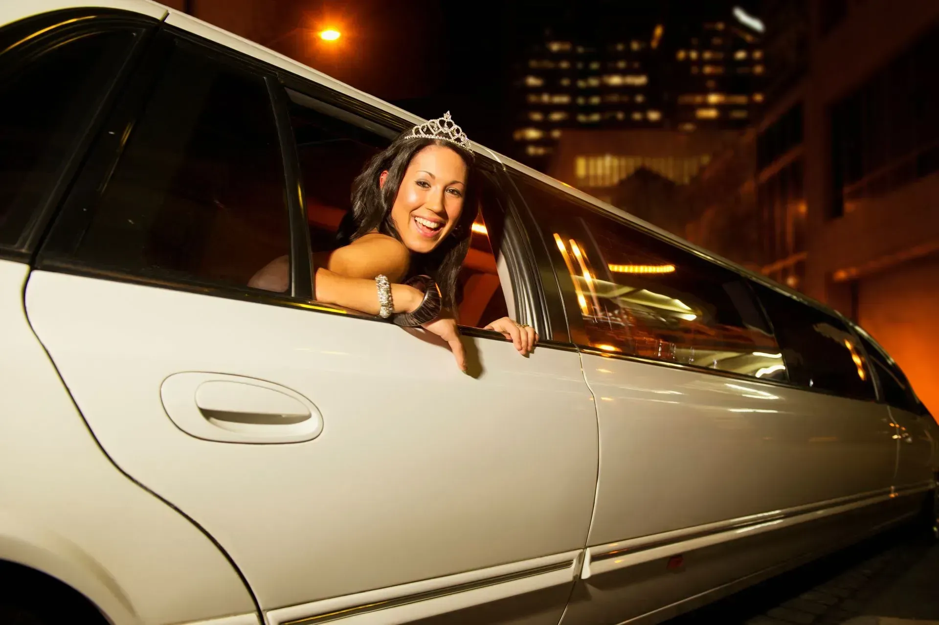 A woman is leaning out of the window of a white limousine.