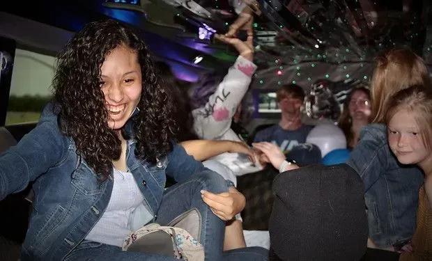 A group of young girls are sitting in a limousine.