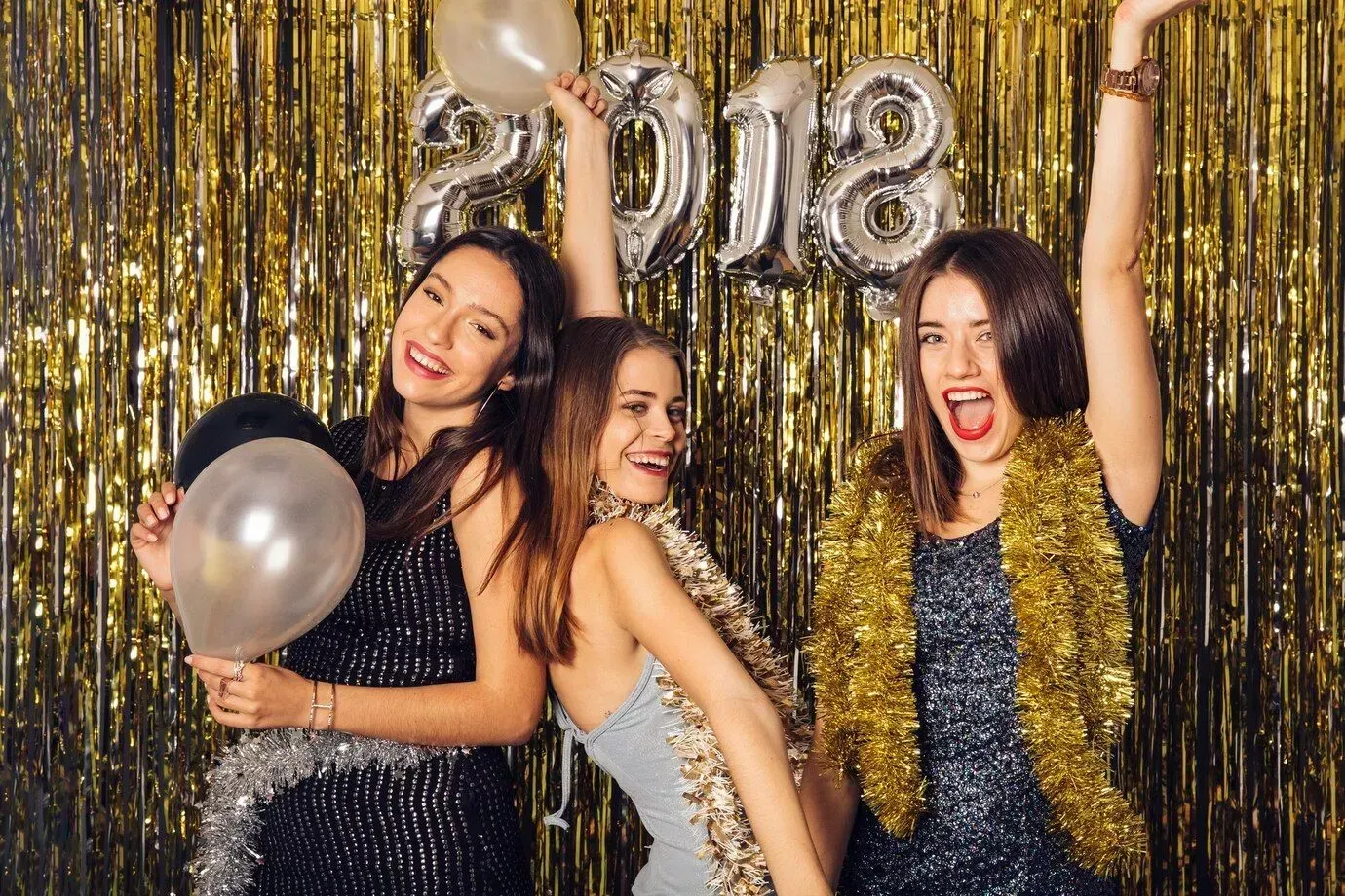 Three women are posing for a picture at a new year 's eve party.