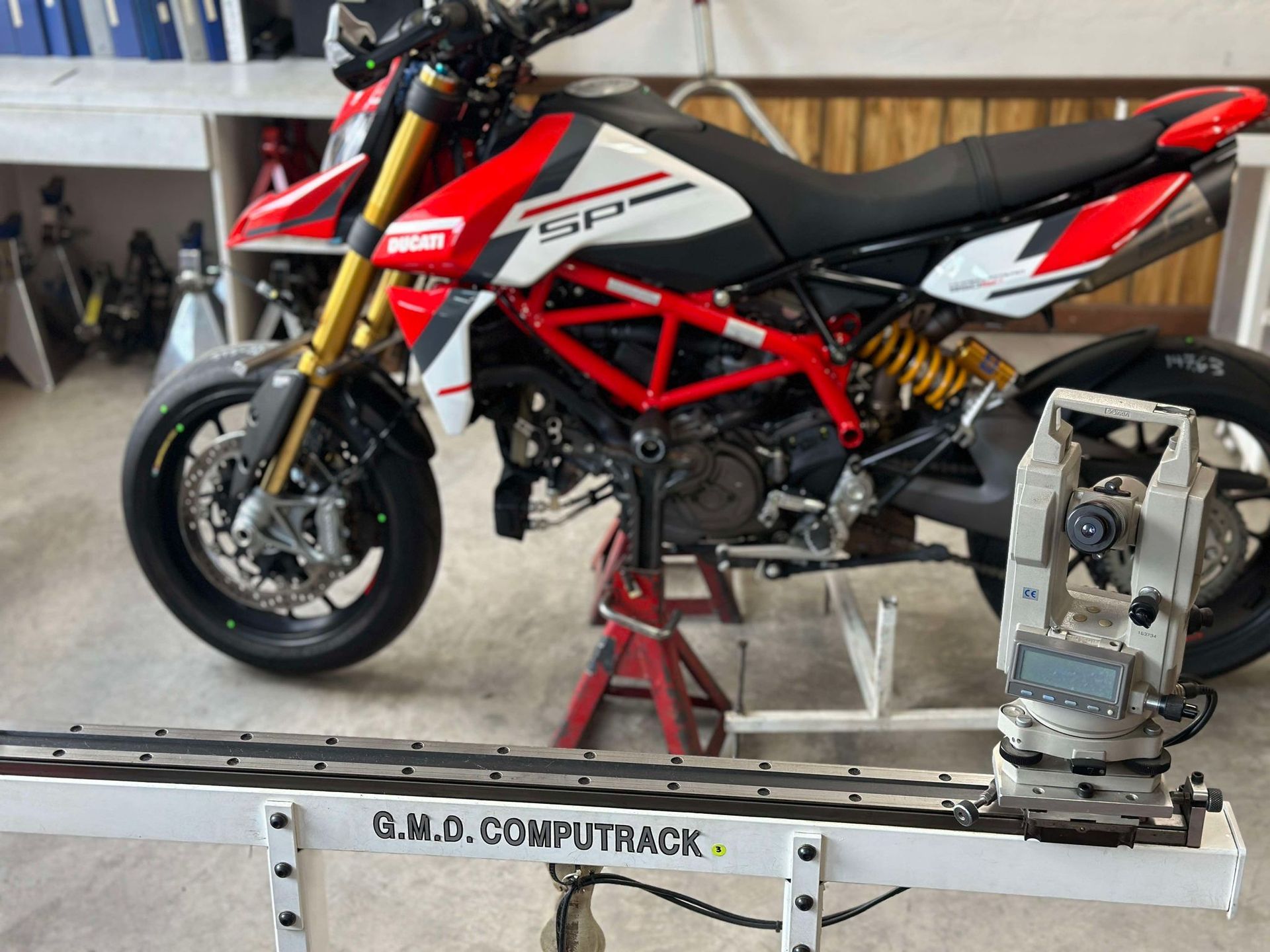 A red and white motorcycle is sitting on a computer track