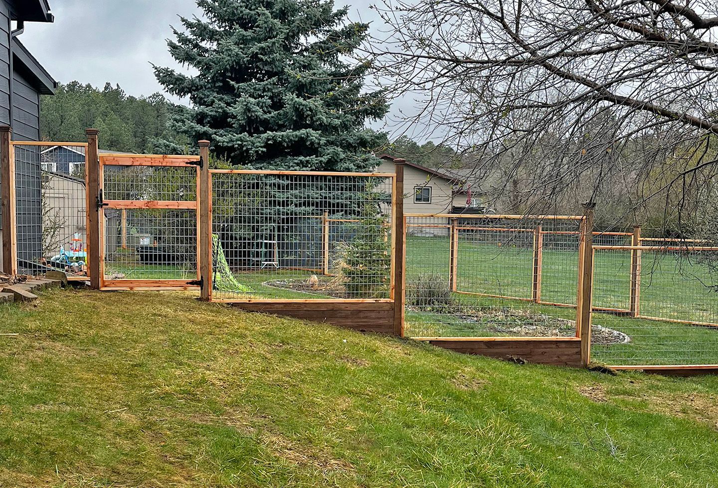 Wooden garden fence with gate in backyard.
