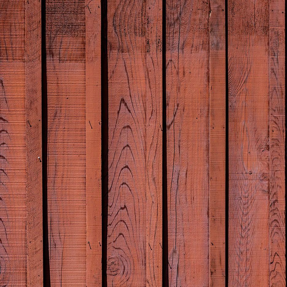 Red-brown wooden planks arranged vertically, showing wood grain details.