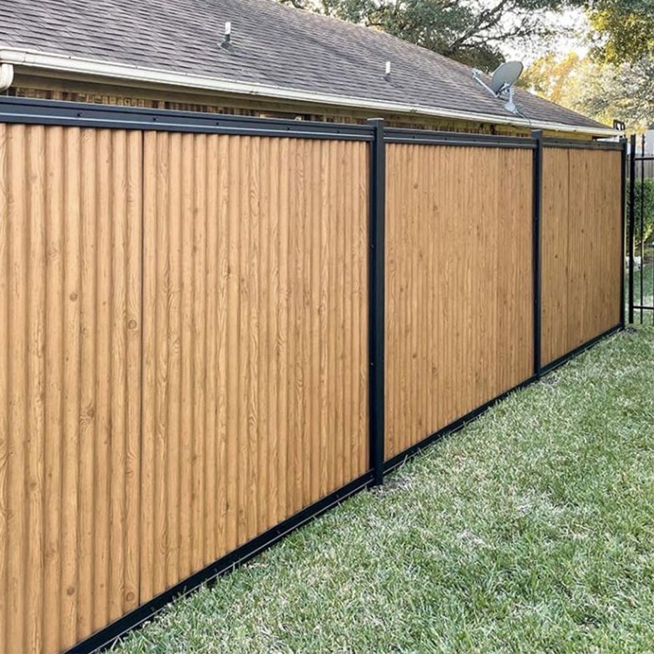 Brown vertical wood fence with black metal frame, alongside a grassy yard.