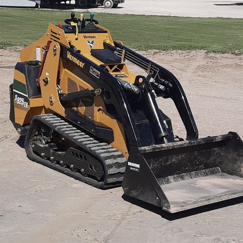 Yellow and black Vermeer mini skid steer loader with bucket on pavement.