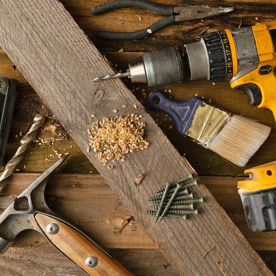 Tools and wood pieces arranged on a wooden surface for a DIY project.