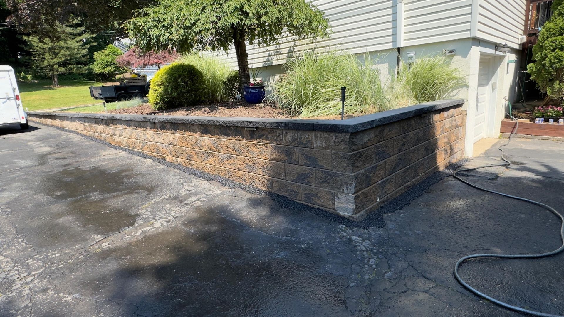 Construction workers placing large stone blocks to build a retaining wall.