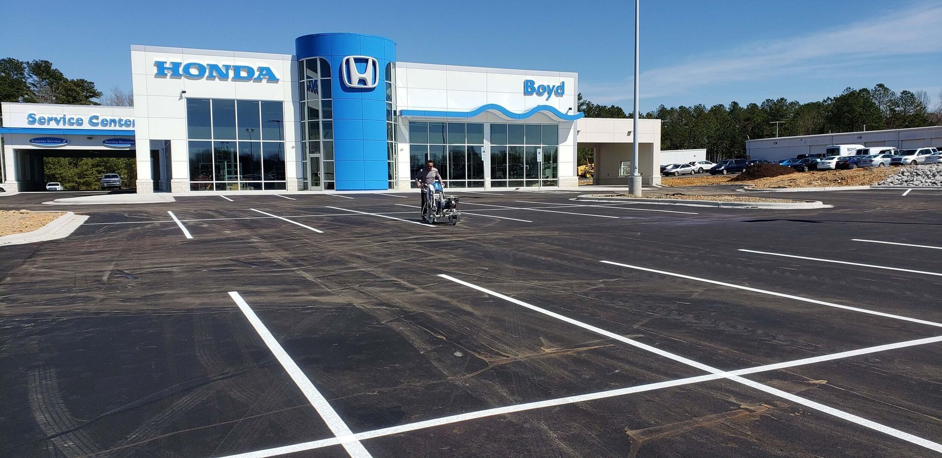 A honda dealership with a parking lot in front of it