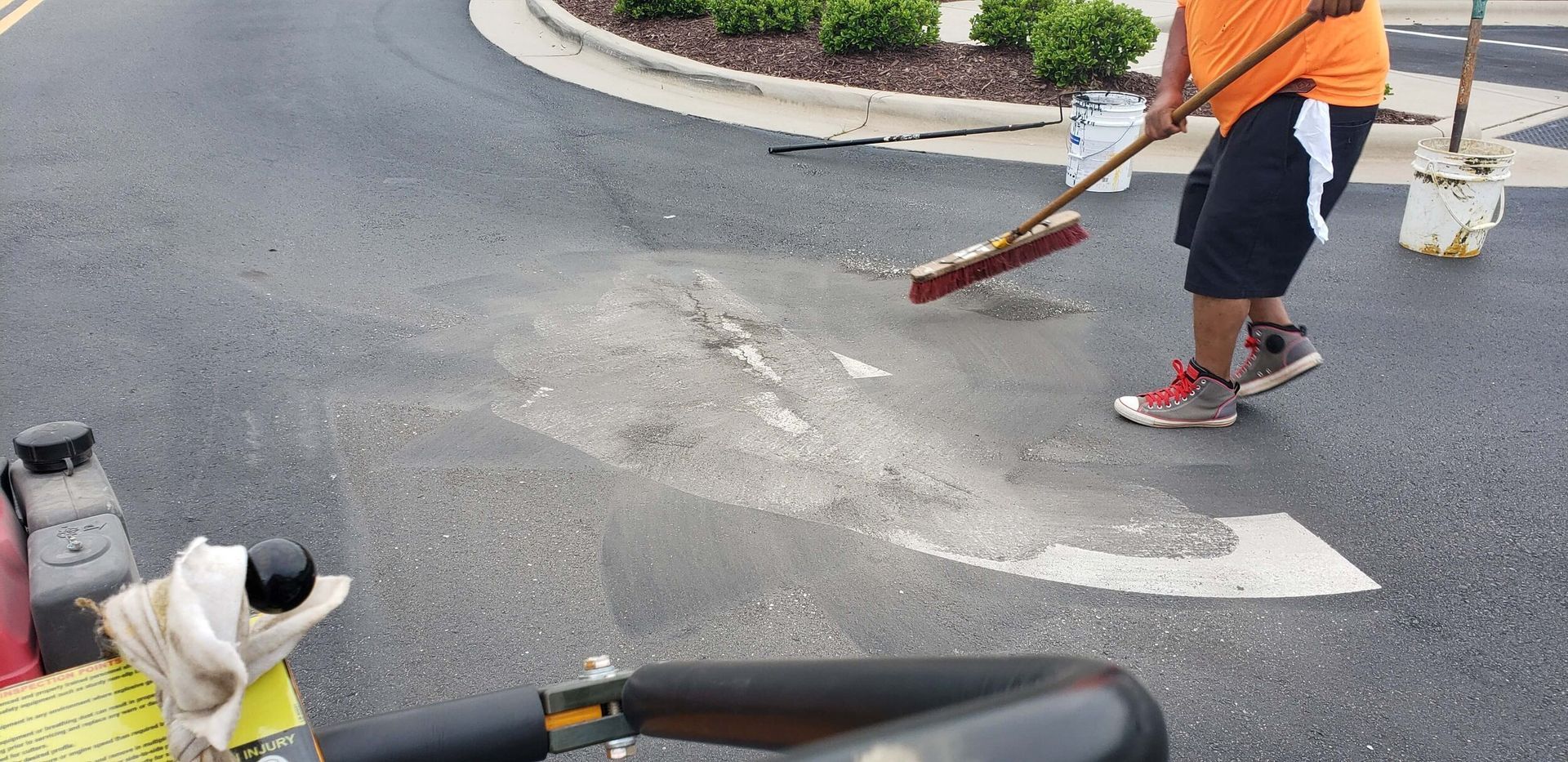 A man is sweeping the road with a broom