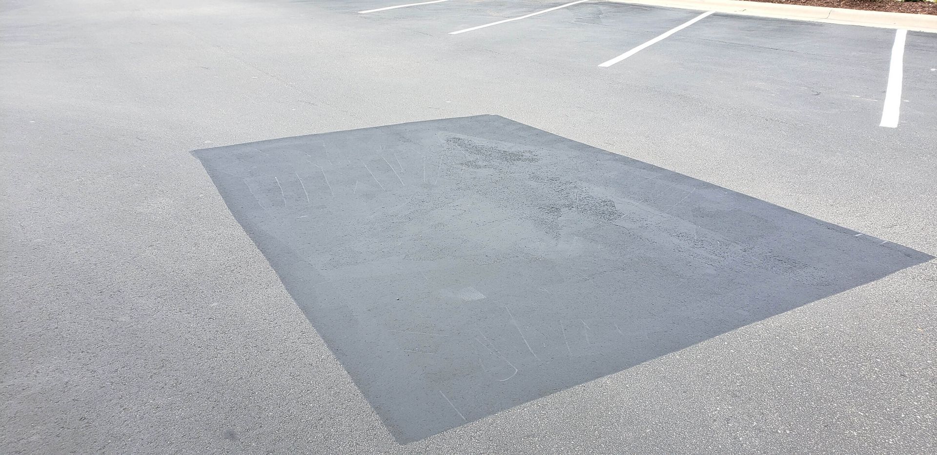 A large patch of asphalt in a parking lot.