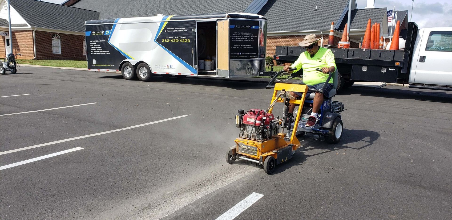 A man is driving a lawn mower on a parking lot.