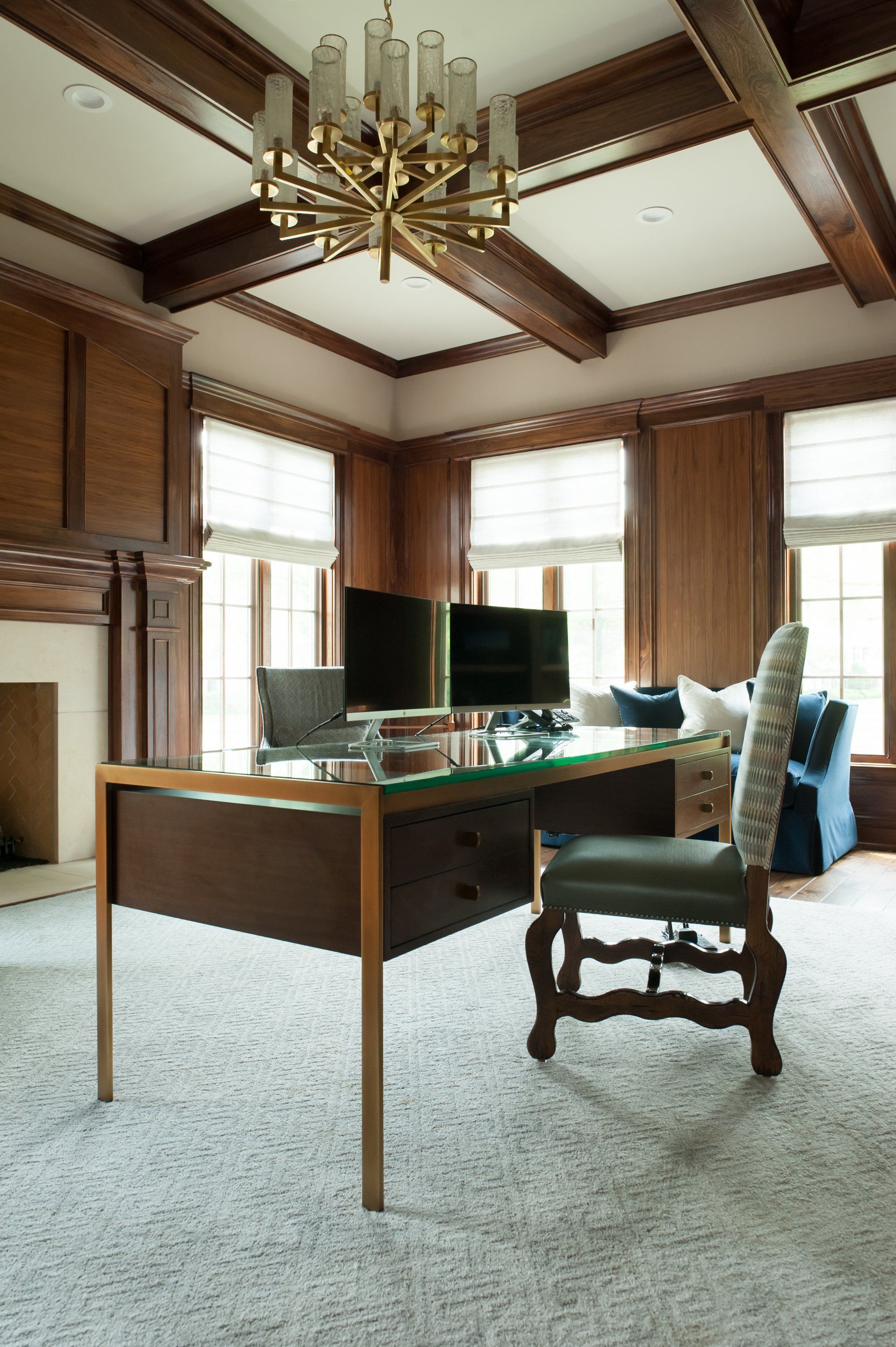 There is a desk in the middle of the room with two computers on it.