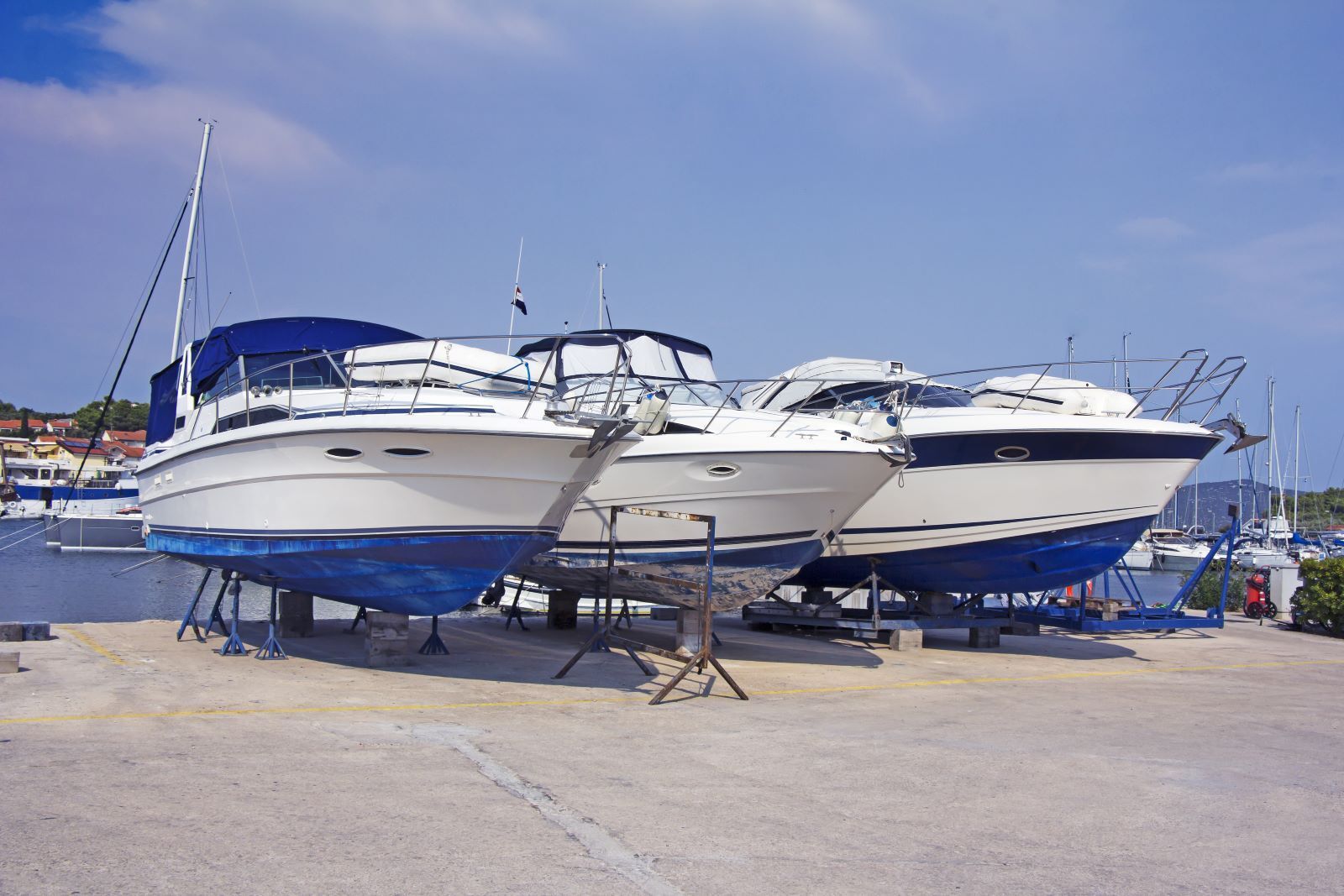 A row of boats are parked in a marina on a sunny day.