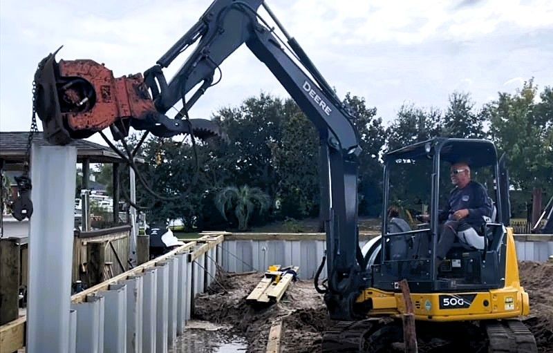 Seawall installation by professional marine contractor using excavator for Tampa waterfront property
