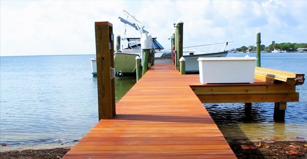 Wooden dock with boat on calm water.