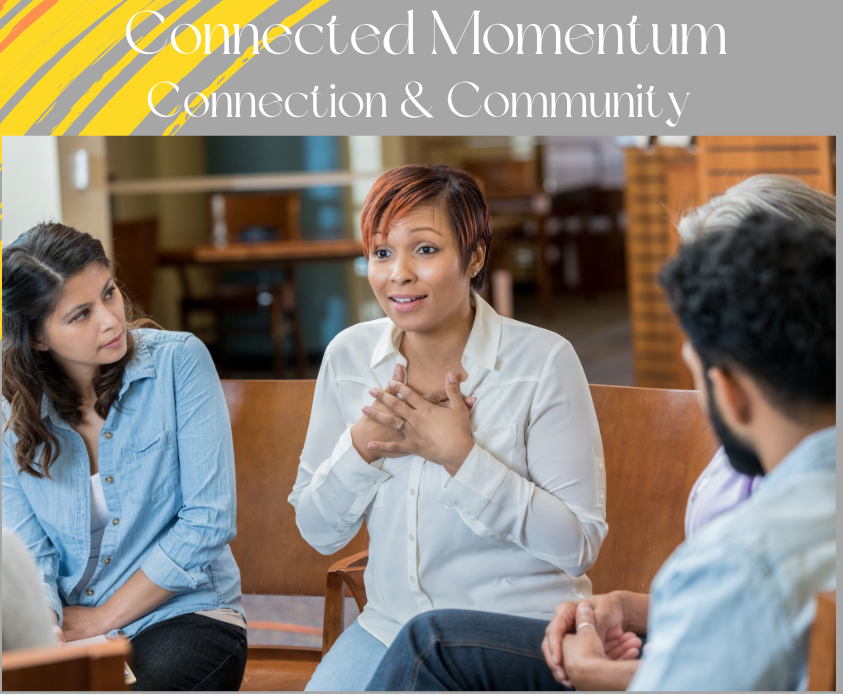 A diverse group of people in a group session, one woman speaking with hands on her chest.