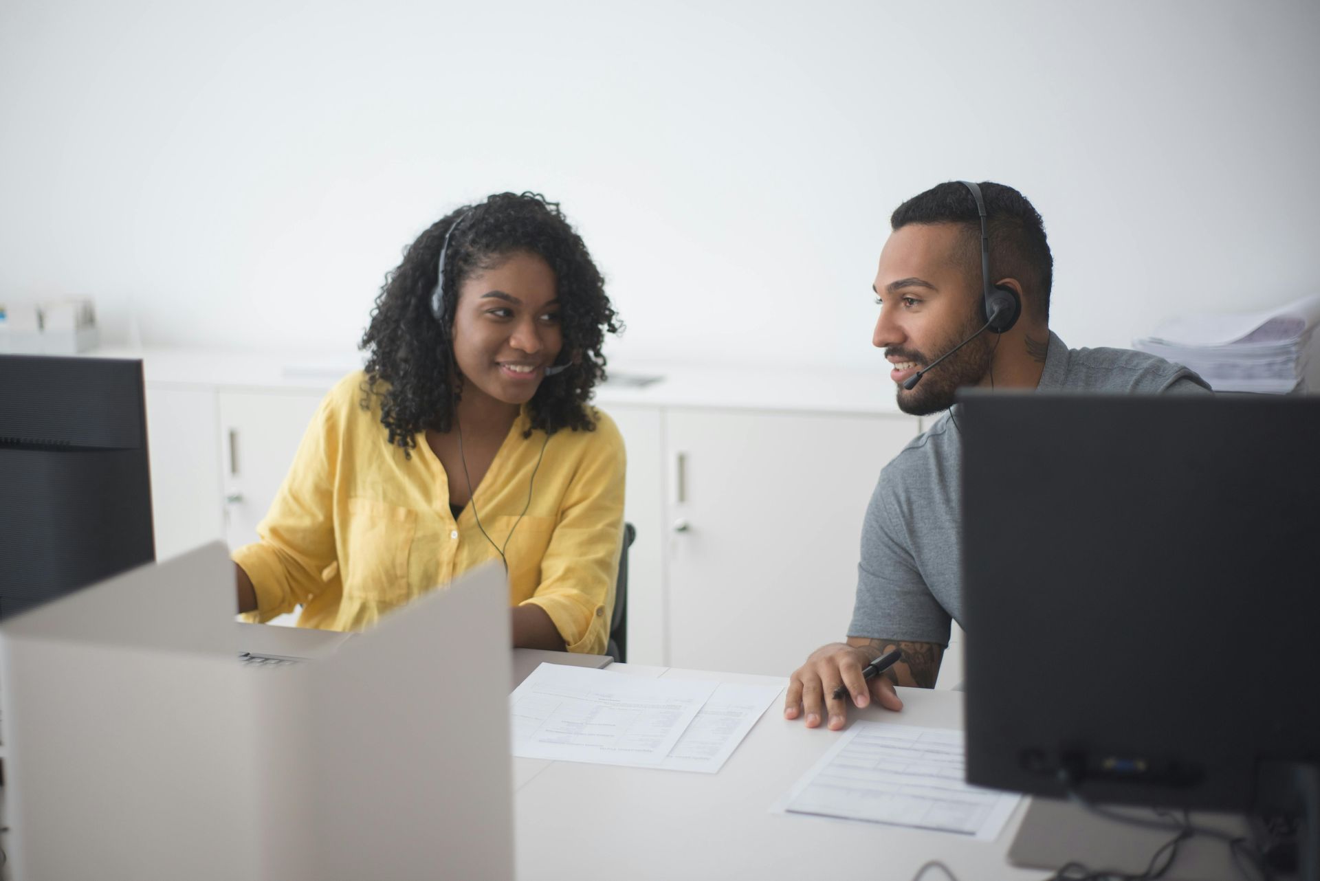 A group of diverse women stand together in a modern office setting. They are representing an organization training session.