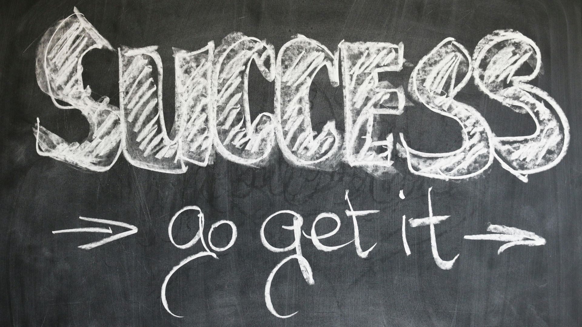 A blackboard with the words success go get it written on it