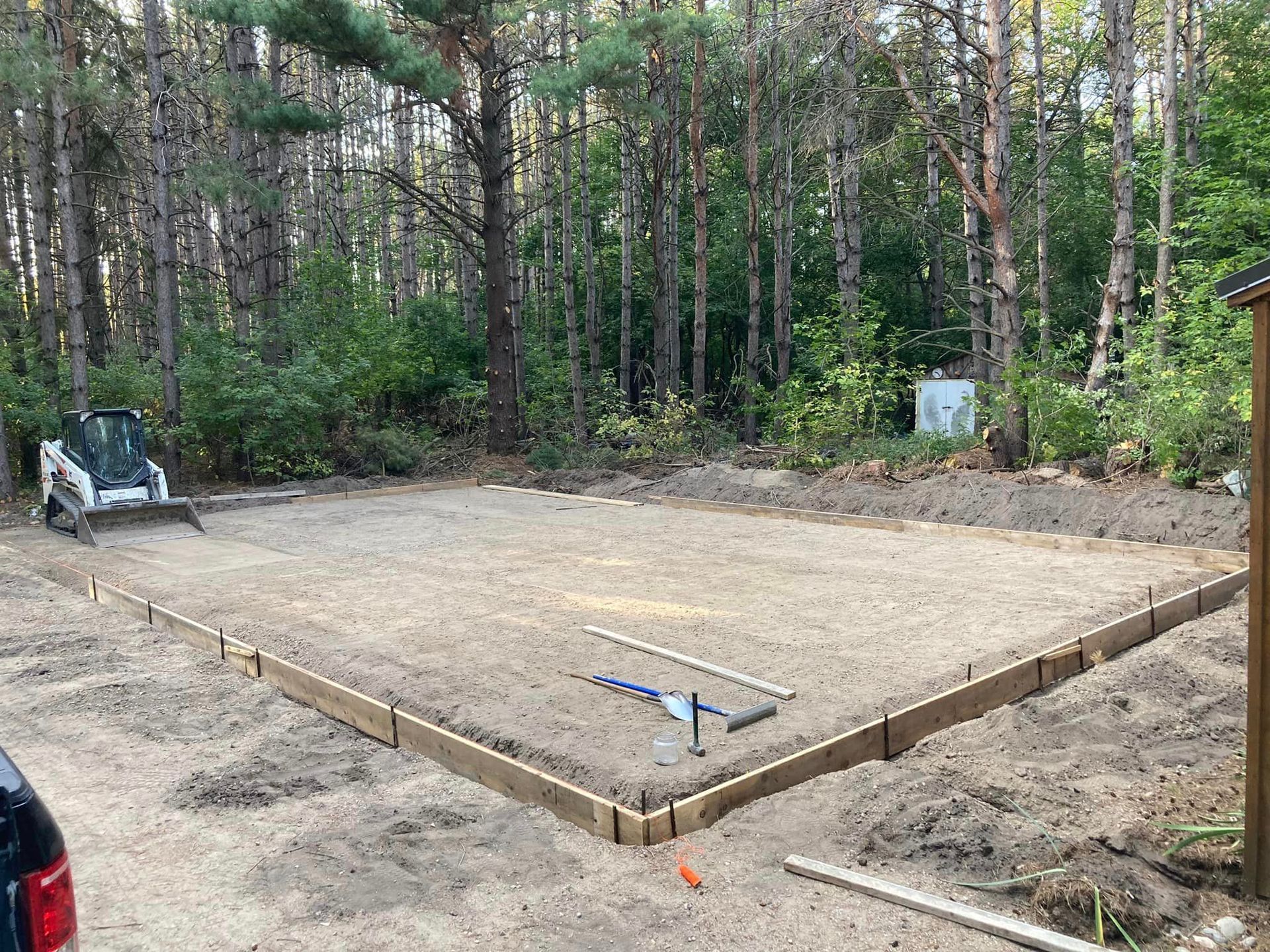 A concrete base is being built in the middle of a forest.