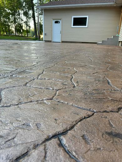 A concrete driveway in front of a house with a white door.