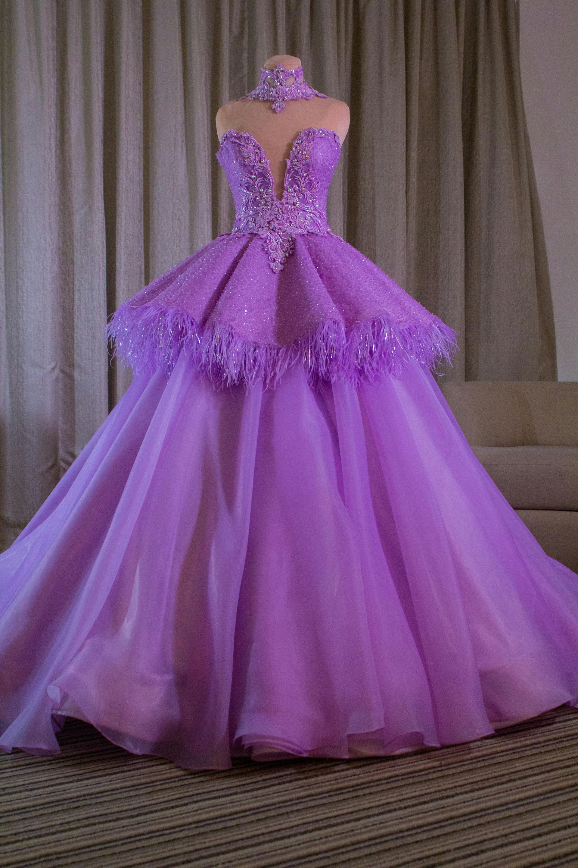 Purple formal gown on a mannequin, with layers of tulle and embellished bodice.
