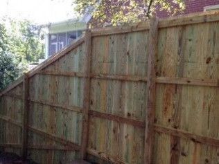 Wooden privacy fence with vertical boards, angled supports, and posts; exterior.