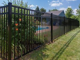 Black metal fence encloses a backyard with pool and lush greenery.