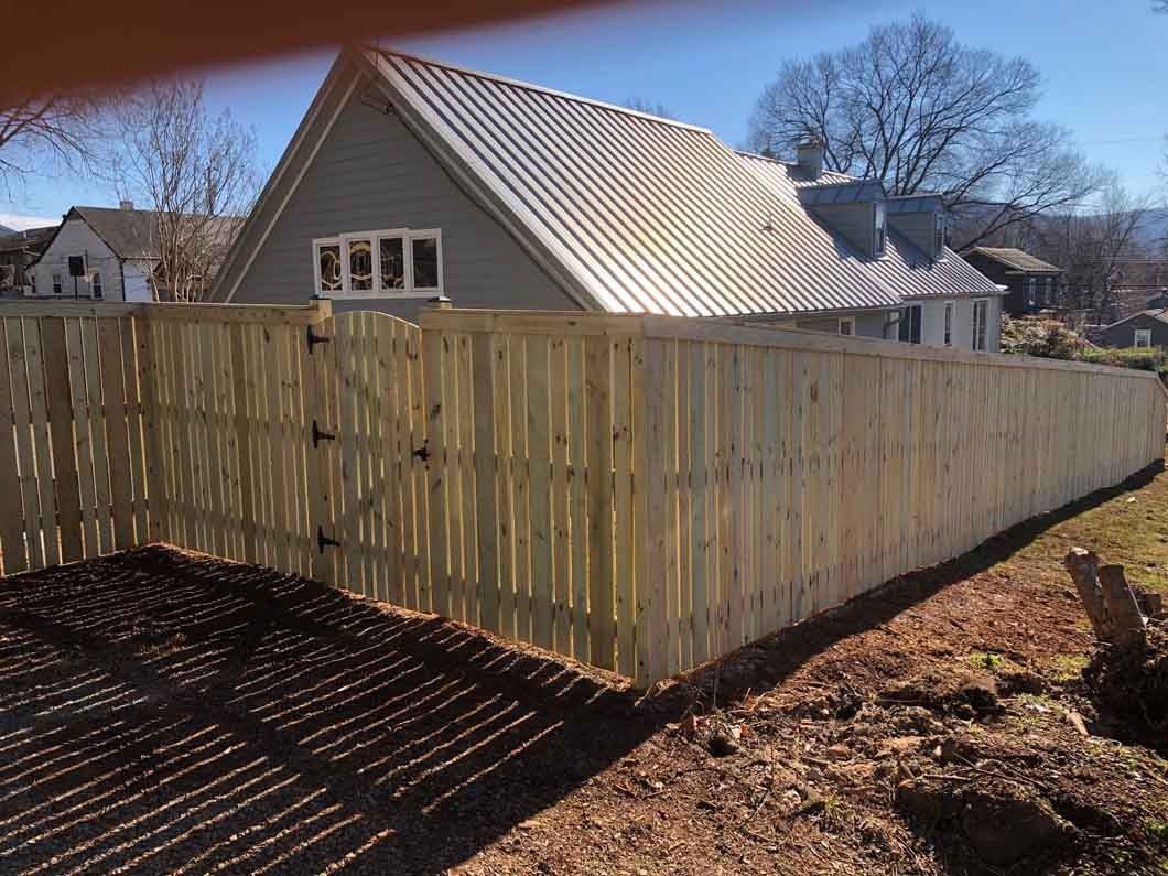 Wooden fence in front of a house, sunny day.