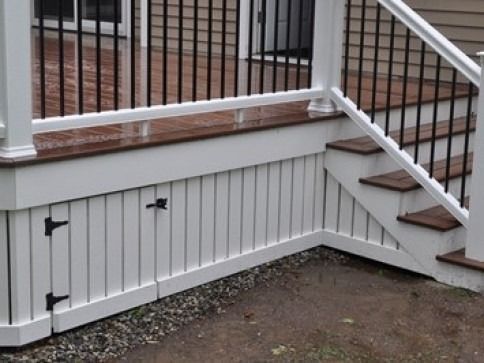 White deck with dark railing and stairs. White siding below the deck, accented with dark hardware.